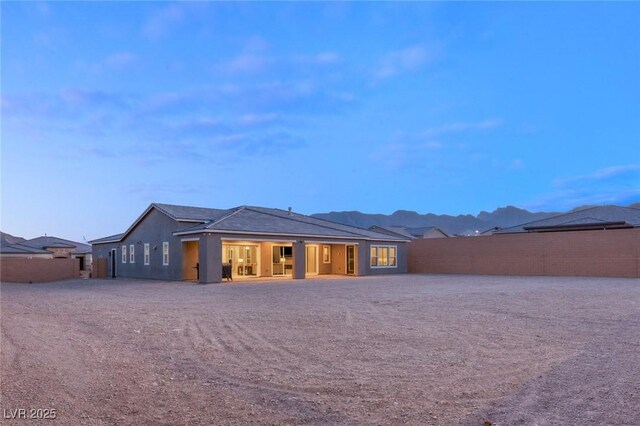 back of property featuring fence and stucco siding