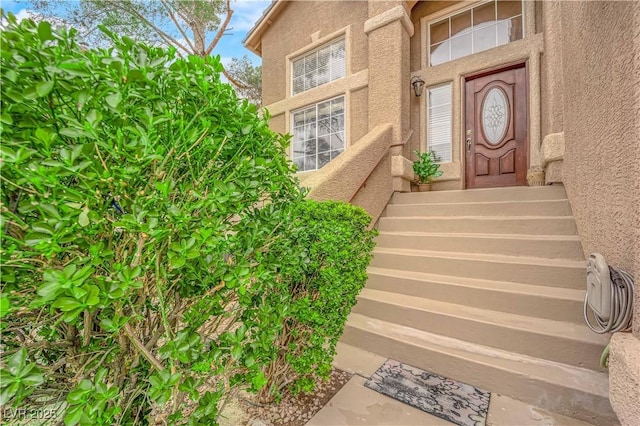 entrance to property featuring stucco siding