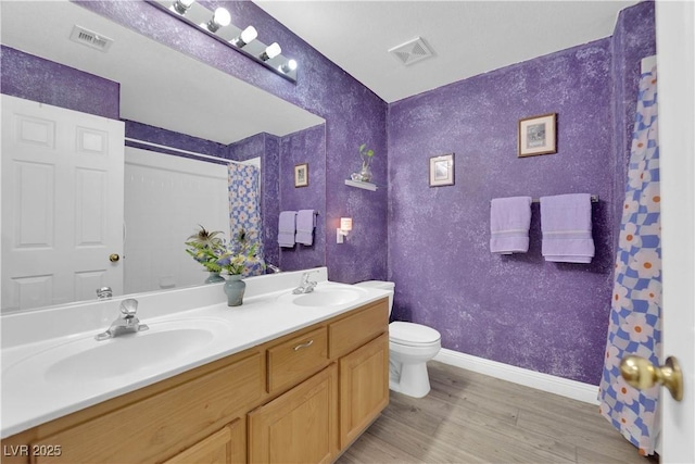 full bath with toilet, wood finished floors, visible vents, and a sink