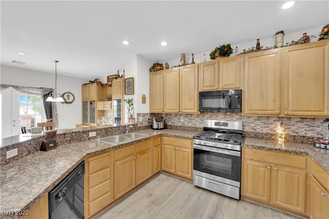 kitchen with a sink, black appliances, and light brown cabinets