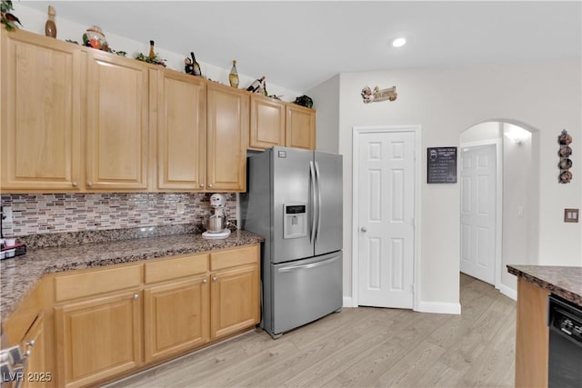 kitchen with tasteful backsplash, black dishwasher, stainless steel fridge with ice dispenser, and arched walkways