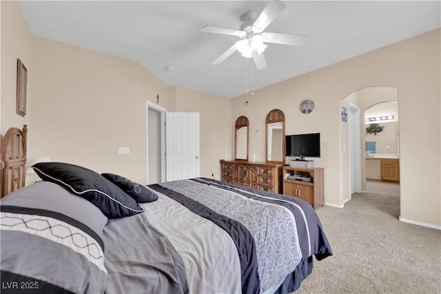 carpeted bedroom with a ceiling fan, lofted ceiling, baseboards, and arched walkways