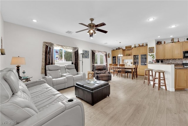 living area with visible vents, recessed lighting, light wood-type flooring, and ceiling fan