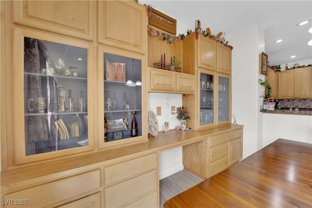 kitchen featuring decorative backsplash, recessed lighting, light brown cabinets, and glass insert cabinets