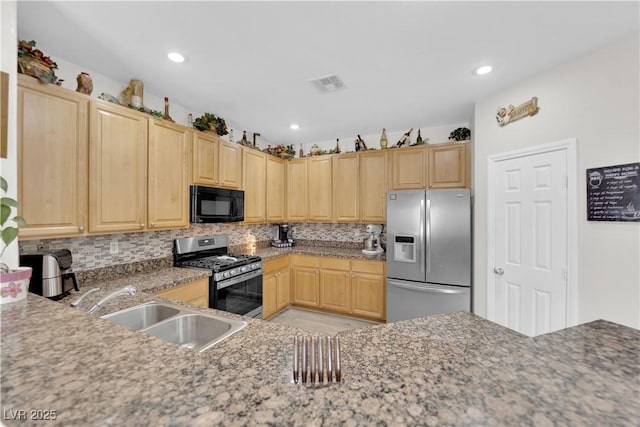 kitchen with light brown cabinets, visible vents, appliances with stainless steel finishes, and a sink