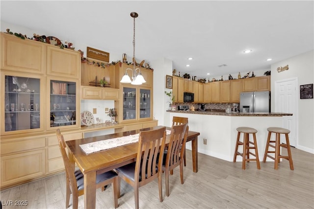 dining room with recessed lighting and light wood-type flooring