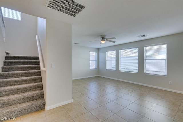 spare room with light tile patterned floors, visible vents, stairway, and ceiling fan