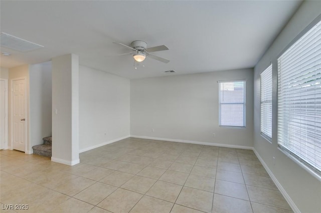 empty room with light tile patterned floors, baseboards, and a ceiling fan