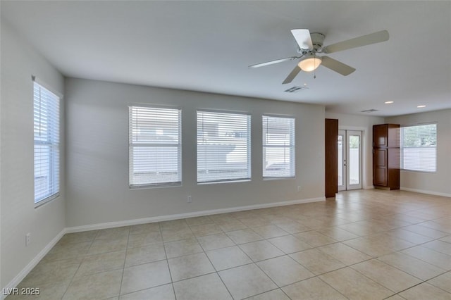 spare room with light tile patterned floors, visible vents, baseboards, and ceiling fan