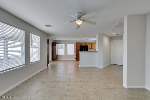 unfurnished living room featuring light tile patterned floors, baseboards, visible vents, and ceiling fan