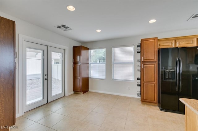 kitchen with black fridge with ice dispenser, recessed lighting, french doors, and visible vents