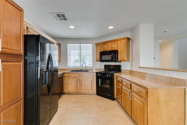 kitchen with visible vents, black appliances, a sink, a peninsula, and light tile patterned floors