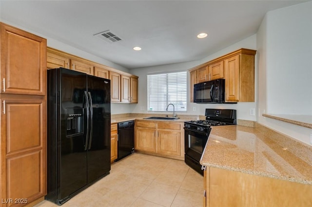 kitchen with light stone countertops, visible vents, recessed lighting, a sink, and black appliances