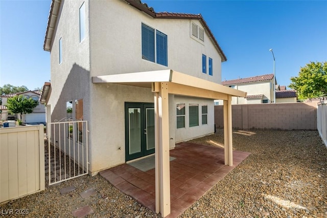 back of property with stucco siding, a fenced backyard, and a patio area