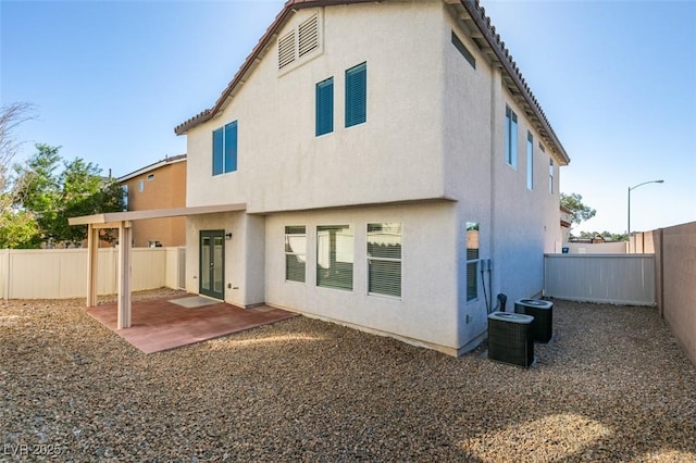 rear view of property featuring stucco siding, a patio, and a fenced backyard