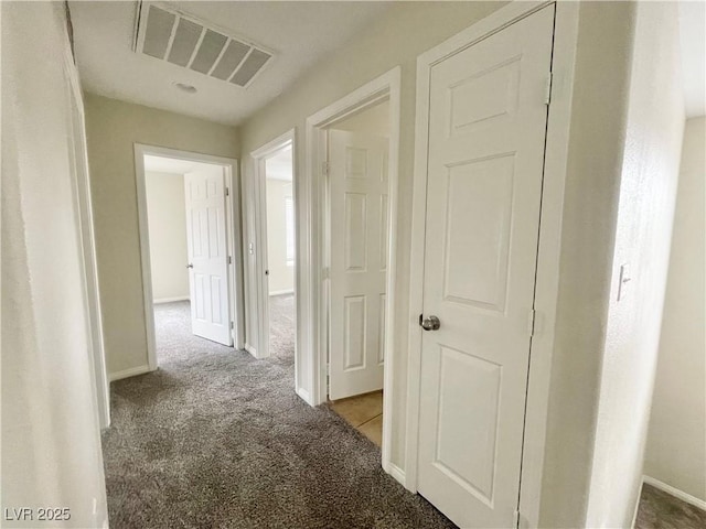 corridor with visible vents, baseboards, and carpet