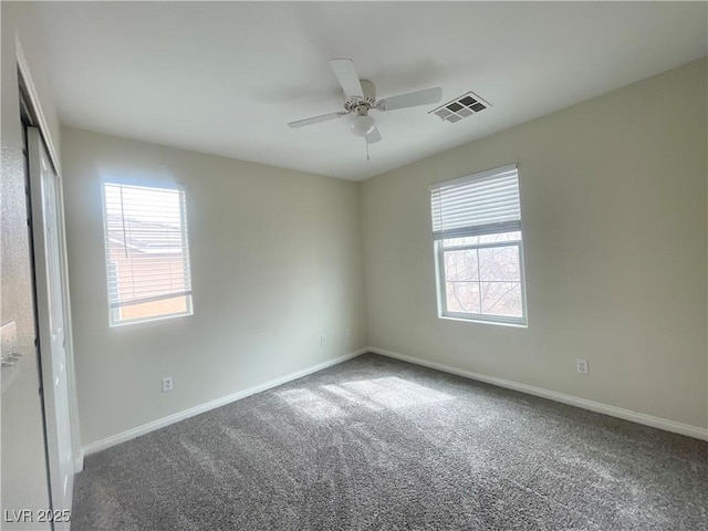 carpeted spare room featuring a ceiling fan, baseboards, and visible vents