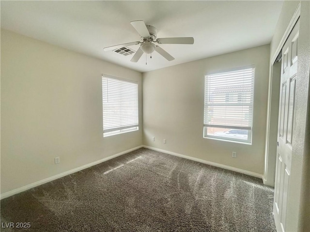 unfurnished bedroom with multiple windows, baseboards, visible vents, and carpet floors