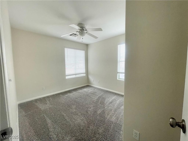 carpeted spare room featuring visible vents, baseboards, and a ceiling fan