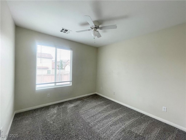 unfurnished room featuring a ceiling fan, visible vents, dark carpet, and baseboards