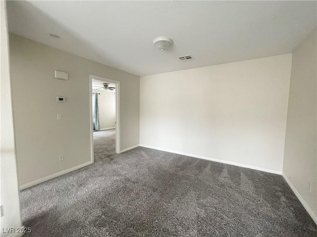 carpeted spare room with visible vents, ceiling fan, and baseboards