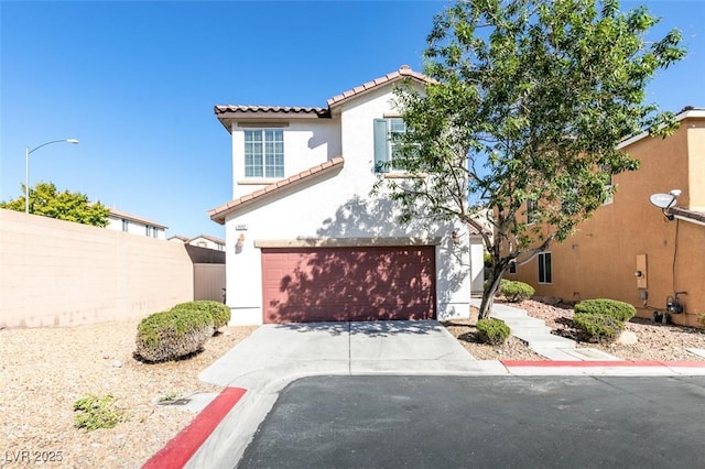 mediterranean / spanish home with fence, a tile roof, stucco siding, driveway, and an attached garage