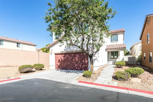 mediterranean / spanish-style home with fence, concrete driveway, a tile roof, stucco siding, and a garage