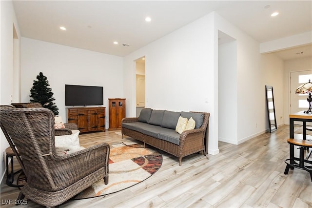 living area featuring visible vents, light wood-style flooring, recessed lighting, and baseboards