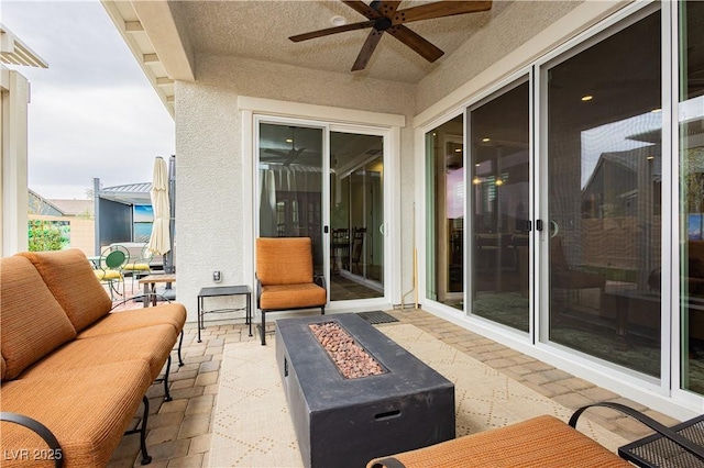 view of patio / terrace featuring an outdoor living space with a fire pit and ceiling fan