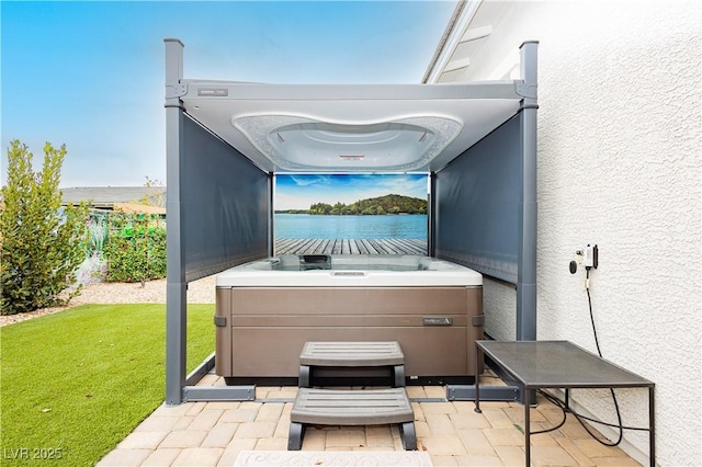 view of patio / terrace with a water view and a hot tub