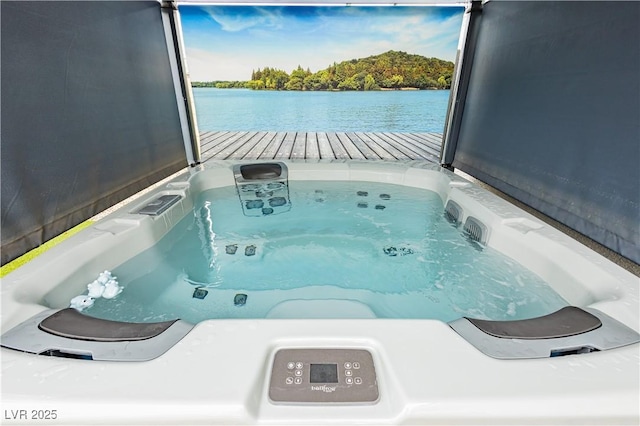 view of pool featuring washer / clothes dryer, an outdoor hot tub, and a water view