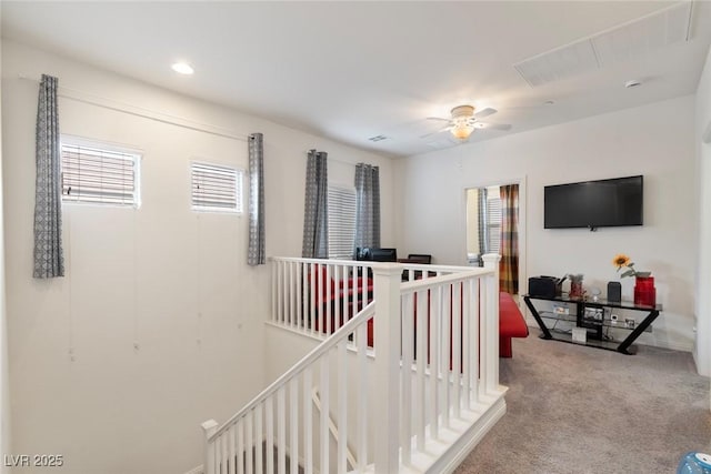 corridor featuring an upstairs landing, recessed lighting, and carpet floors