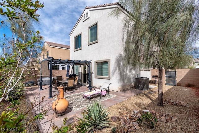 rear view of house with stucco siding, cooling unit, a fenced backyard, a patio area, and a pergola