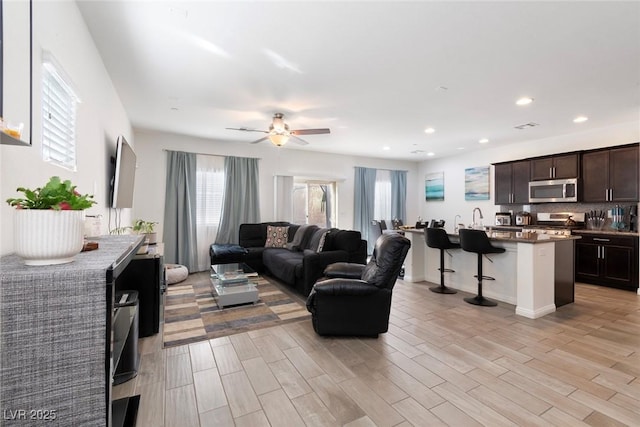 living area featuring recessed lighting, light wood finished floors, and ceiling fan