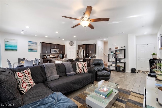 living area with recessed lighting, light wood-type flooring, visible vents, and a ceiling fan