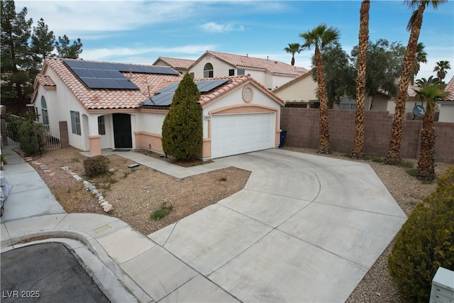 mediterranean / spanish home with a tiled roof, fence, driveway, and stucco siding