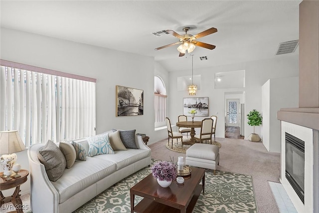 living room with visible vents, a fireplace with flush hearth, carpet, and ceiling fan