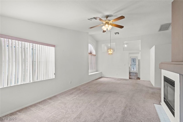 unfurnished living room with visible vents, a fireplace with flush hearth, carpet, and ceiling fan