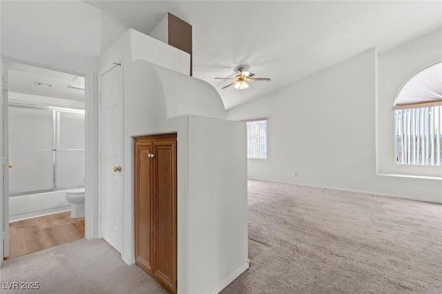 corridor featuring lofted ceiling and light carpet