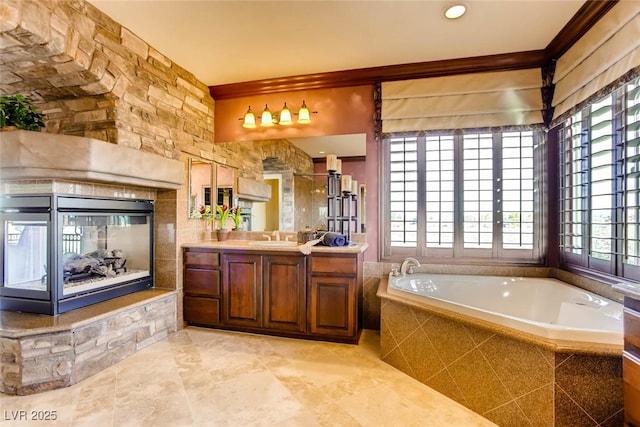 bathroom featuring vanity, crown molding, and a garden tub