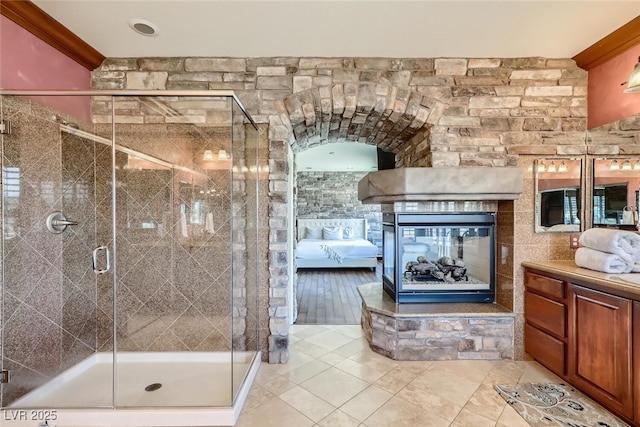 full bathroom with a stall shower, vanity, ensuite bathroom, and a fireplace