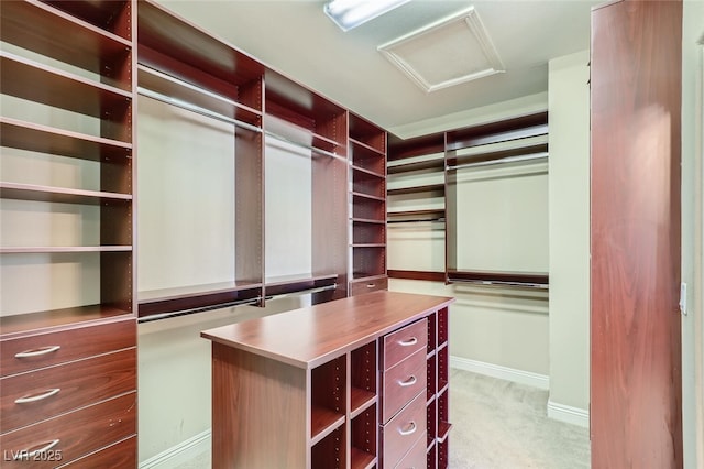 spacious closet featuring light colored carpet and attic access