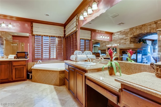 full bathroom with a bath, a stall shower, two vanities, and a sink