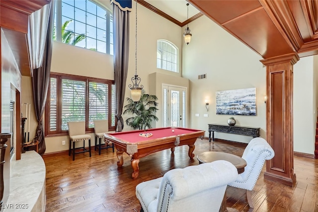 rec room with visible vents, hardwood / wood-style floors, crown molding, and ornate columns