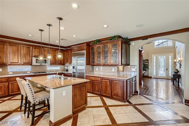 kitchen featuring decorative backsplash, a sink, baseboards, and stainless steel appliances