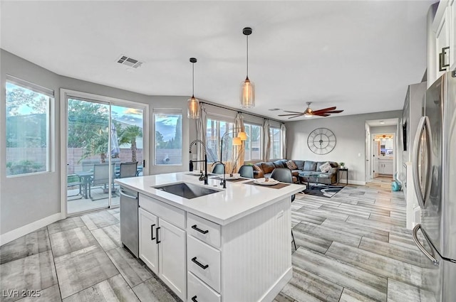 kitchen with visible vents, a sink, light countertops, appliances with stainless steel finishes, and open floor plan