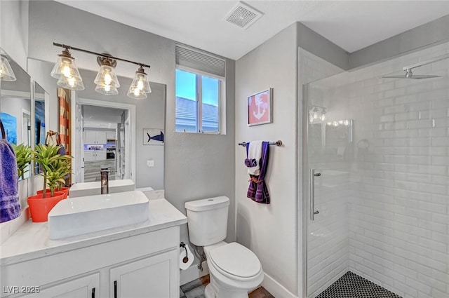 full bathroom featuring vanity, baseboards, visible vents, a stall shower, and toilet