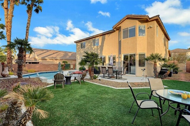 back of house with a fenced in pool, a fenced backyard, stucco siding, a patio area, and a lawn