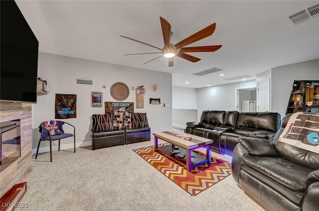 carpeted living area featuring visible vents, baseboards, ceiling fan, and a tiled fireplace