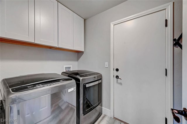 clothes washing area with light wood-style flooring, cabinet space, and independent washer and dryer